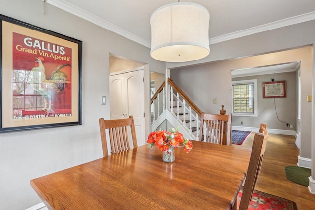 dining room with ornamental molding, wood finished floors, stairs, and baseboards