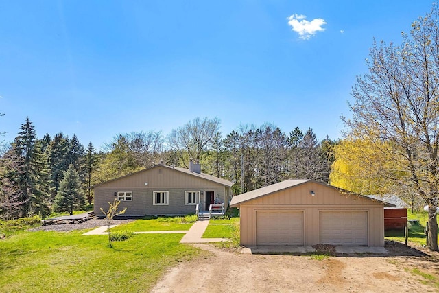 W3256 Princeton Rd, Green Lake, WI 54941 - view of front facade with a garage, an outdoor structure, a front yard, a chimney, and a wooded view