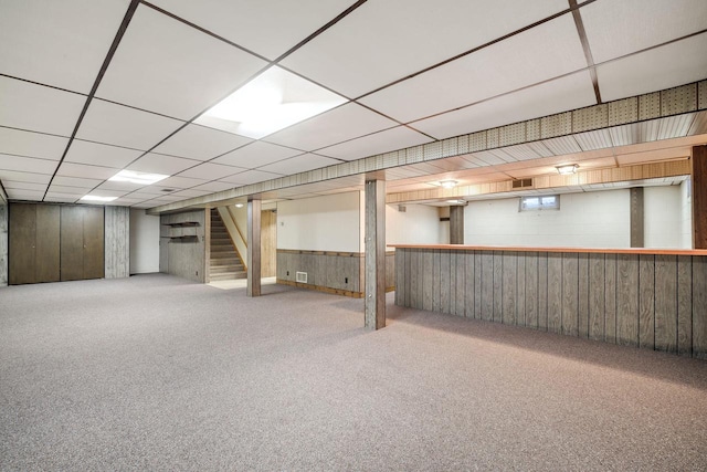 7704 Salisbury Rd, West Bend, WI 53090 - finished basement with carpet, stairs, wooden walls, and a paneled ceiling