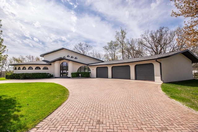 4455 Club Dr, Slinger, WI 53086 - mediterranean / spanish-style home featuring stucco siding, curved driveway, a garage, and a front yard