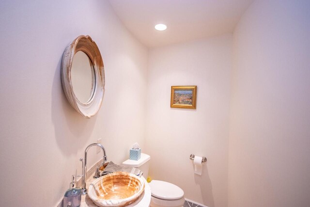 4455 Club Dr, Slinger, WI 53086 - half bath featuring a sink, toilet, and baseboards