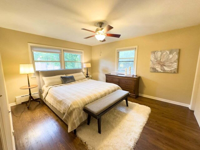 7814 2nd Ave, Kenosha, WI 53143 - bedroom featuring a baseboard radiator, dark wood-type flooring, baseboards, and a ceiling fan