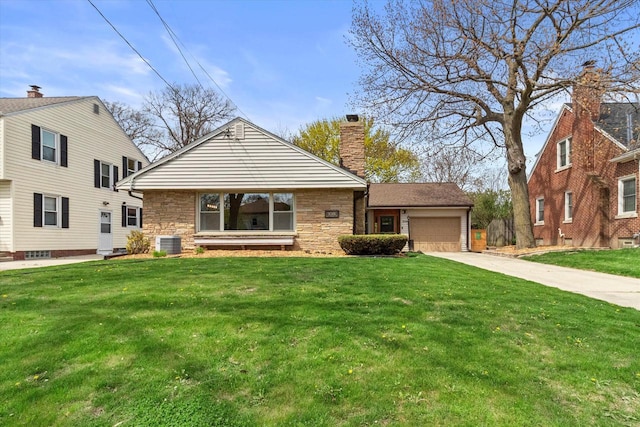view of front facade with a front lawn, a chimney, an attached garage, driveway, and stone siding