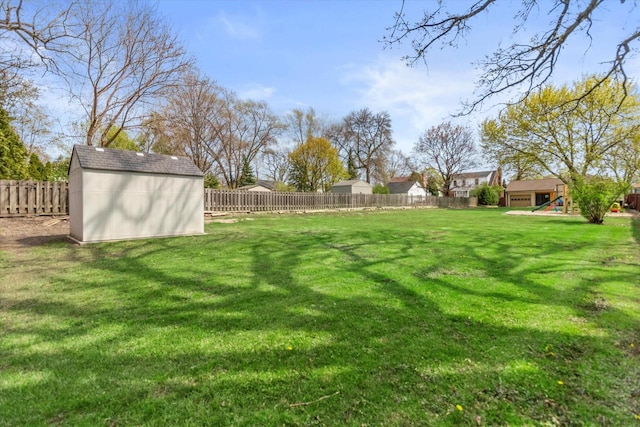 view of yard featuring a storage shed, an outbuilding, and a playground