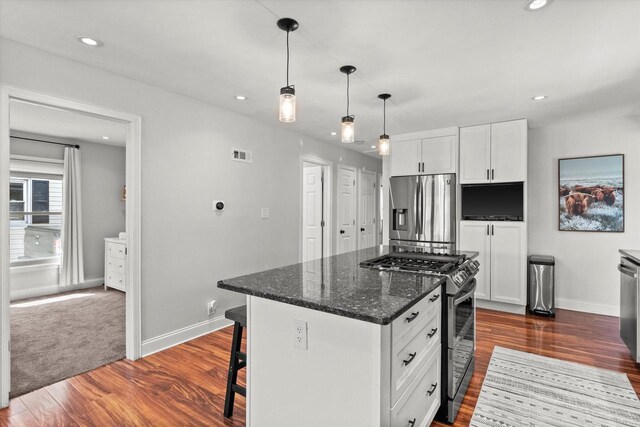 kitchen with appliances with stainless steel finishes, baseboards, white cabinetry, dark wood finished floors, and recessed lighting