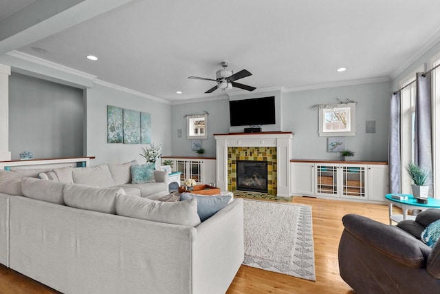 519 Park Ave, Little Chute, WI 54140 - living area featuring recessed lighting, ornamental molding, wood finished floors, a ceiling fan, and a tiled fireplace