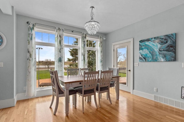 519 Park Ave, Little Chute, WI 54140 - dining room with a chandelier, light wood-style flooring, and healthy amount of natural light