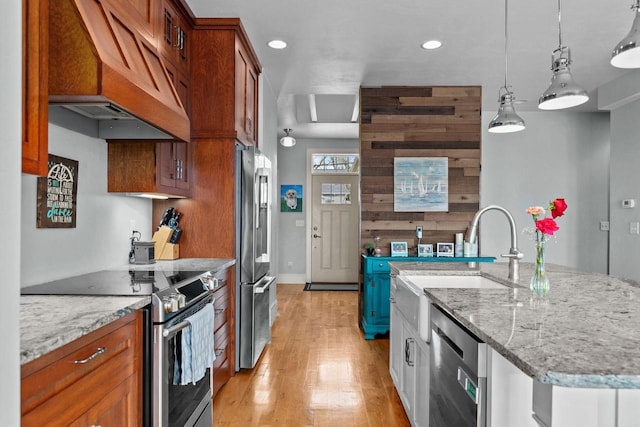 519 Park Ave, Little Chute, WI 54140 - kitchen with stainless steel appliances, custom range hood, light wood-style flooring, light stone counters, and recessed lighting