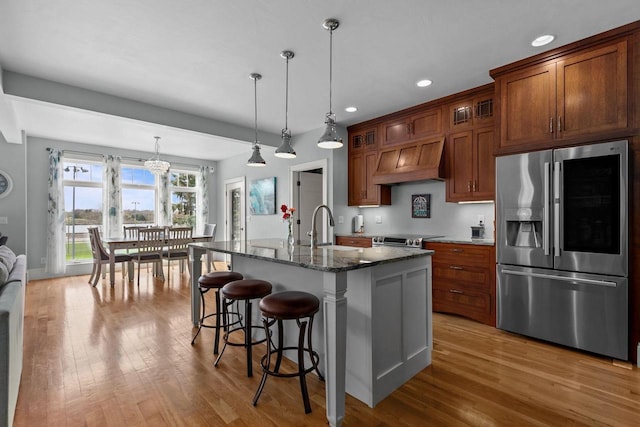 519 Park Ave, Little Chute, WI 54140 - kitchen with appliances with stainless steel finishes, custom range hood, a sink, wood finished floors, and glass insert cabinets