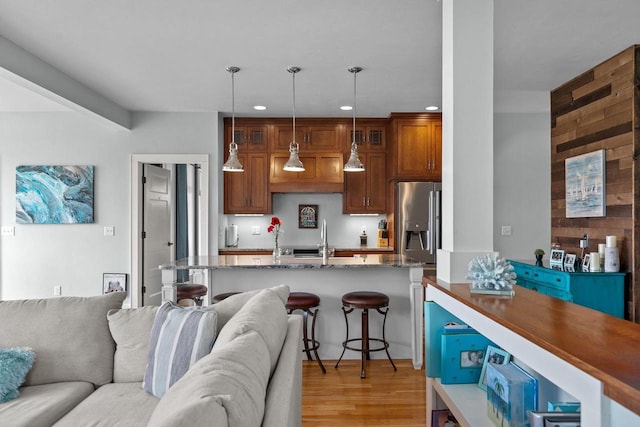 519 Park Ave, Little Chute, WI 54140 - kitchen featuring open floor plan, stainless steel refrigerator with ice dispenser, recessed lighting, a breakfast bar, and light wood-type flooring