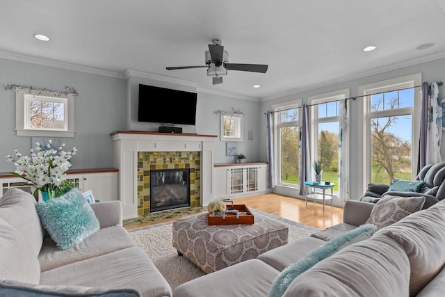 519 Park Ave, Little Chute, WI 54140 - living area featuring ornamental molding, wood finished floors, a ceiling fan, recessed lighting, and a tiled fireplace