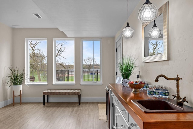 519 Park Ave, Little Chute, WI 54140 - kitchen with a sink, butcher block counters, light wood-type flooring, baseboards, and pendant lighting