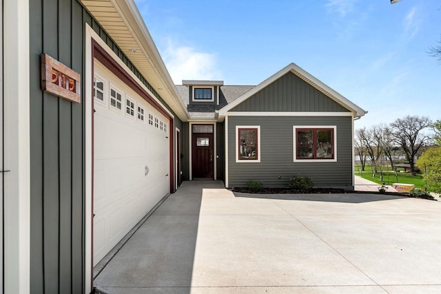 519 Park Ave, Little Chute, WI 54140 - view of front facade with board and batten siding, a garage, and roof with shingles