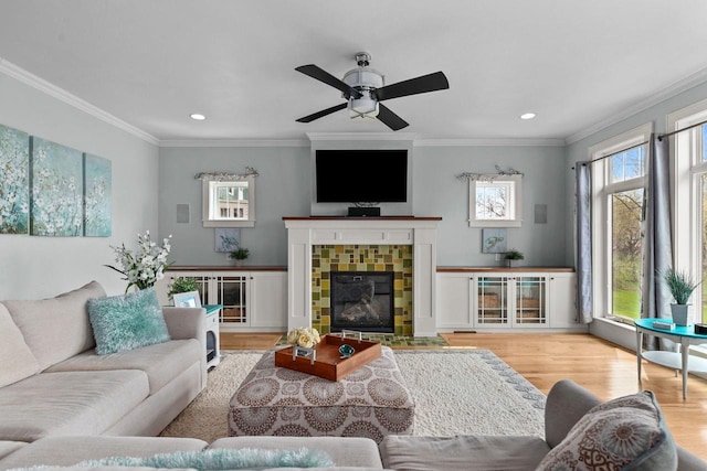519 Park Ave, Little Chute, WI 54140 - living room featuring wood finished floors, ornamental molding, recessed lighting, ceiling fan, and a tiled fireplace