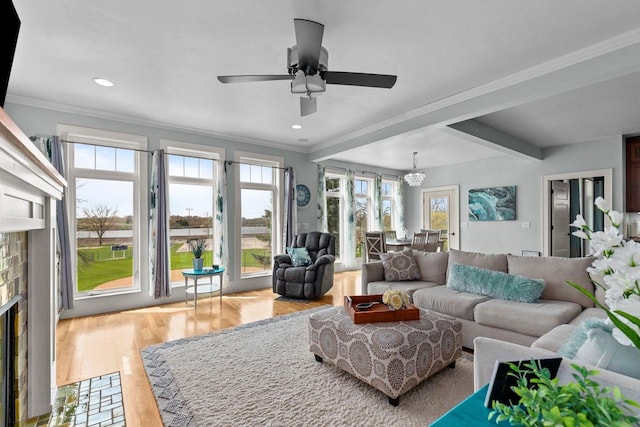 519 Park Ave, Little Chute, WI 54140 - living room with a fireplace, a ceiling fan, plenty of natural light, a chandelier, and ornamental molding