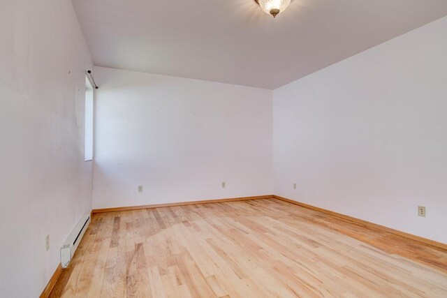 1600 26th Ave, Menominee, MI 49858 - empty room with a baseboard heating unit, wood finished floors, and baseboards