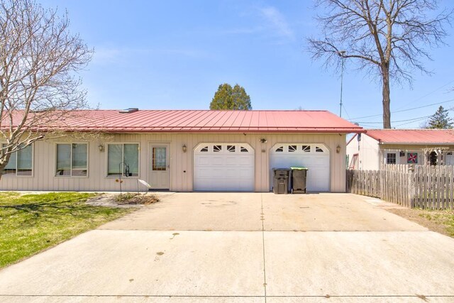 1600 26th Ave, Menominee, MI 49858 - ranch-style home with fence, board and batten siding, concrete driveway, a garage, and metal roof