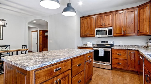 129 Grey Friar Ln, Eau Claire, WI 54701 - kitchen featuring appliances with stainless steel finishes, light wood-style flooring, brown cabinets, and arched walkways