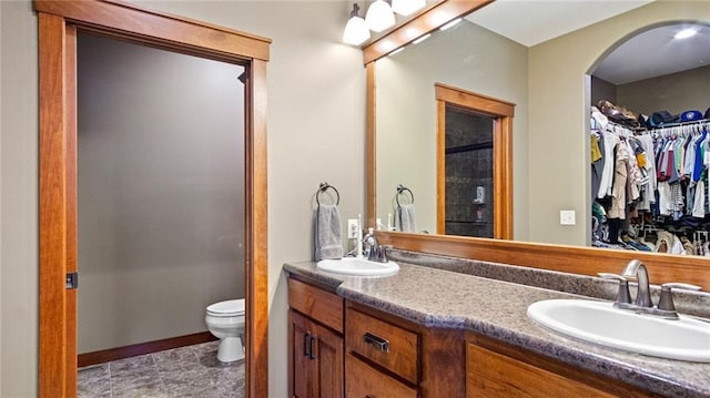 129 Grey Friar Ln, Eau Claire, WI 54701 - bathroom featuring a spacious closet, double vanity, toilet, and baseboards