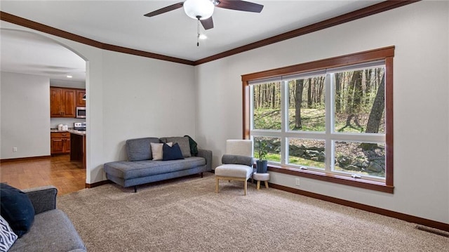 129 Grey Friar Ln, Eau Claire, WI 54701 - living room featuring ornamental molding, baseboards, ceiling fan, arched walkways, and carpet floors