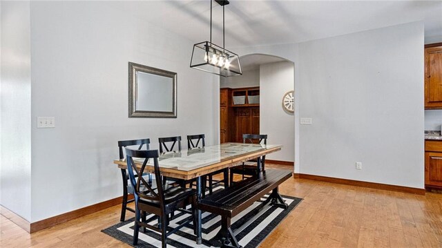 129 Grey Friar Ln, Eau Claire, WI 54701 - dining space featuring arched walkways, light wood-type flooring, and baseboards