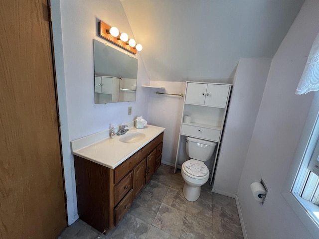 432 S Union St, Mauston, WI 53948 - bathroom featuring baseboards, toilet, vanity, lofted ceiling, and stone finish flooring