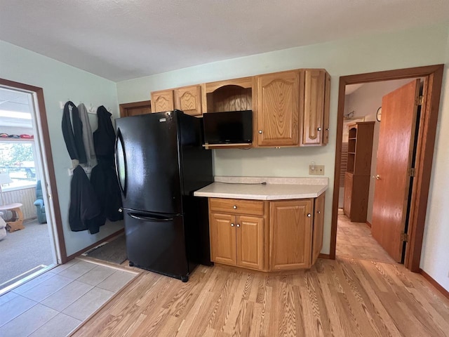 432 S Union St, Mauston, WI 53948 - kitchen featuring freestanding refrigerator, light countertops, and light wood-style flooring