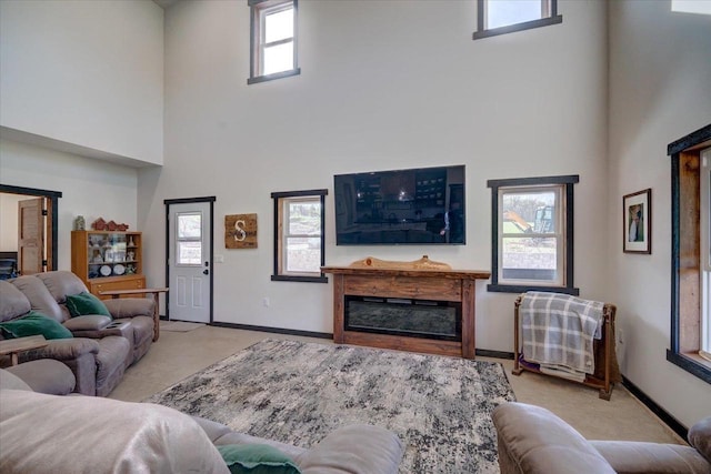 2515 County Road Hk, Barneveld, WI 53507 - living area featuring a high ceiling, baseboards, a glass covered fireplace, and carpet floors