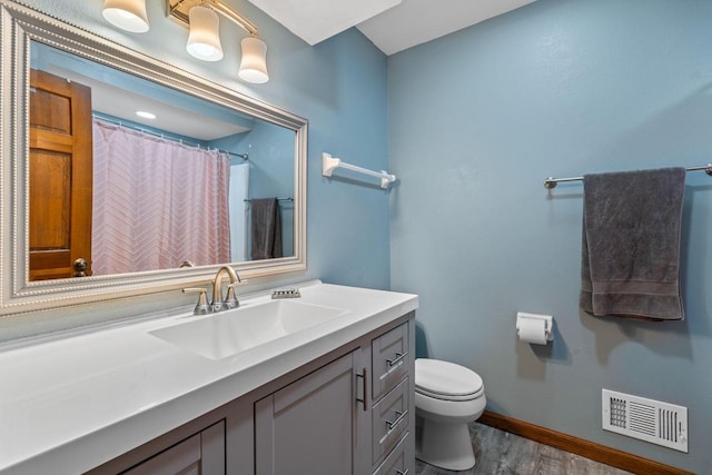 W343S9320 Jericho Dr, Eagle, WI 53119 - bathroom with wood finished floors, toilet, baseboards, and vanity