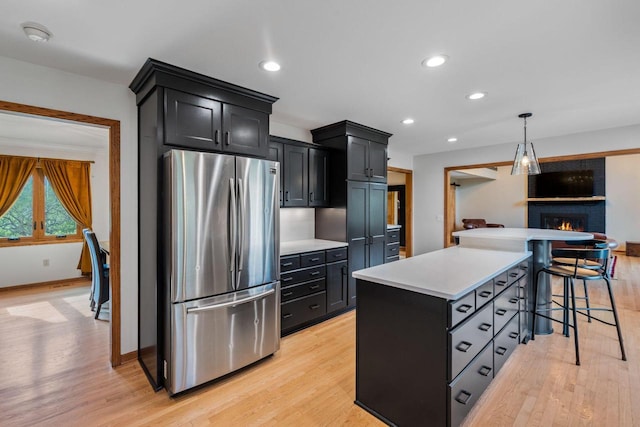 W343S9320 Jericho Dr, Eagle, WI 53119 - kitchen featuring freestanding refrigerator, dark cabinets, light wood finished floors, light countertops, and recessed lighting