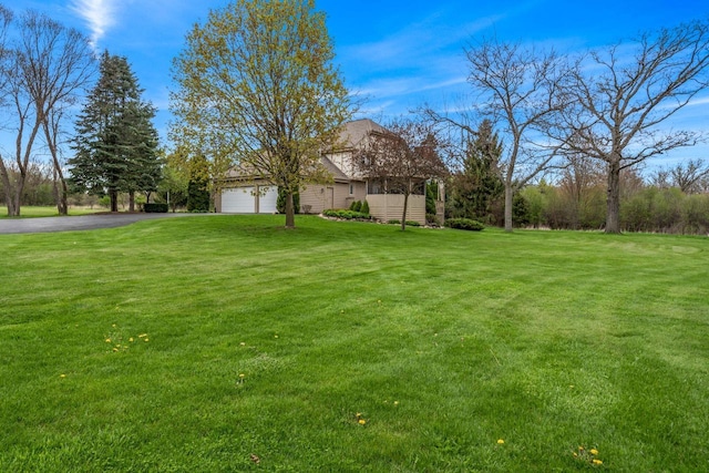 W343S9320 Jericho Dr, Eagle, WI 53119 - view of green lawn with asphalt driveway and an attached garage