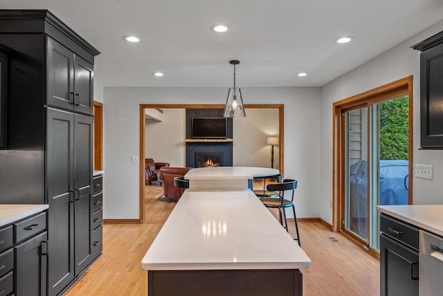 W343S9320 Jericho Dr, Eagle, WI 53119 - kitchen with light countertops, a fireplace, light wood-type flooring, open floor plan, and recessed lighting