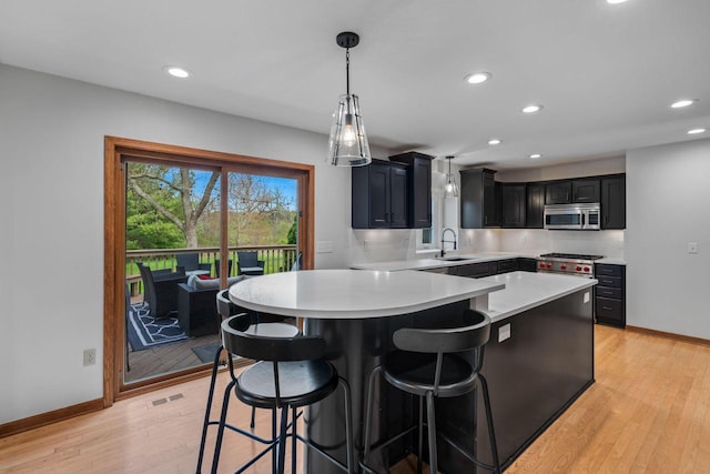 W343S9320 Jericho Dr, Eagle, WI 53119 - kitchen with stainless steel microwave, a sink, light countertops, a breakfast bar, and baseboards