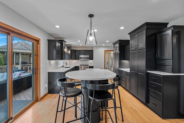 W343S9320 Jericho Dr, Eagle, WI 53119 - kitchen with stainless steel appliances, a sink, dark cabinetry, light countertops, and light wood-style flooring