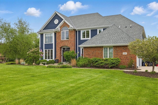 628 Sedge Meadow Ct, Summit, WI 53066 - view of front of property with a front yard, brick siding, and roof with shingles