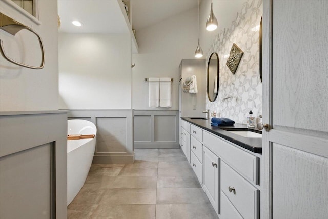 628 Sedge Meadow Ct, Summit, WI 53066 - full bathroom with a wainscoted wall, double vanity, a freestanding bath, tile patterned floors, and a decorative wall