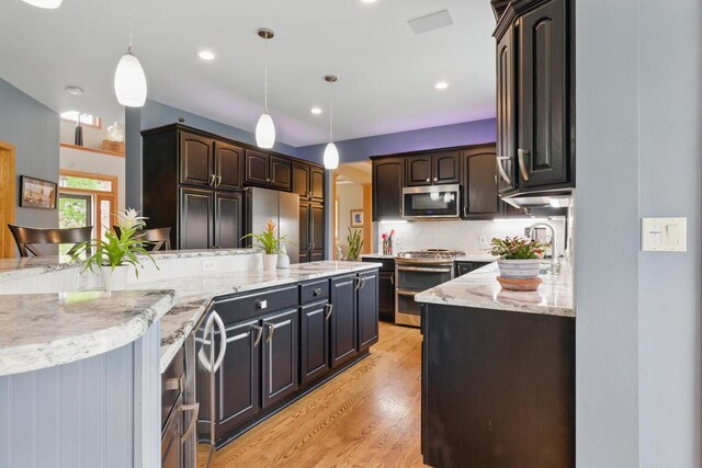628 Sedge Meadow Ct, Summit, WI 53066 - kitchen with stainless steel appliances, decorative backsplash, light wood-style floors, light stone countertops, and recessed lighting
