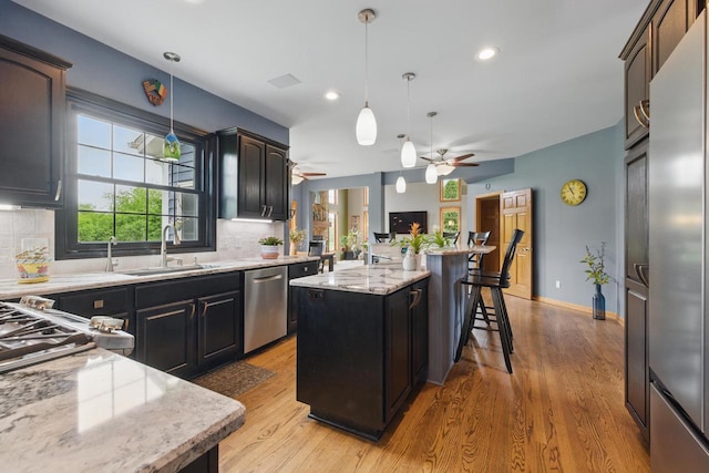 628 Sedge Meadow Ct, Summit, WI 53066 - kitchen featuring ceiling fan, stainless steel appliances, a sink, decorative backsplash, and recessed lighting