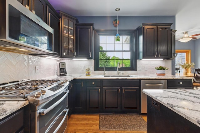 628 Sedge Meadow Ct, Summit, WI 53066 - kitchen with stainless steel appliances, a sink, healthy amount of natural light, and light stone counters