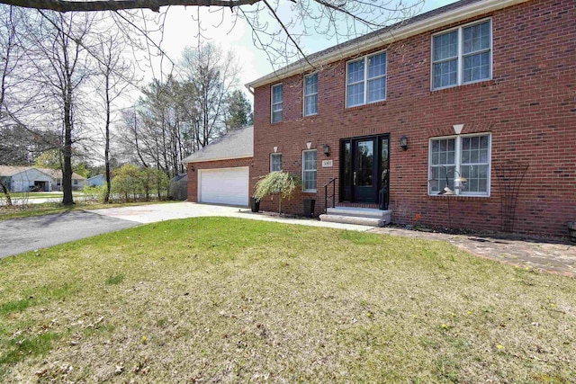 3001 Revere Rd, Plover, WI 54406 - colonial house featuring concrete driveway, an attached garage, a front yard, and brick siding
