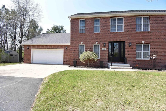 3001 Revere Rd, Plover, WI 54406 - colonial home featuring a front lawn, concrete driveway, a garage, and brick siding