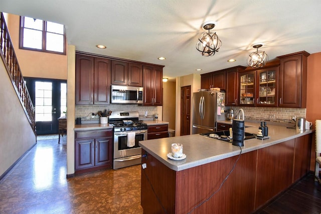 3001 Revere Rd, Plover, WI 54406 - kitchen featuring appliances with stainless steel finishes, a peninsula, glass insert cabinets, tasteful backsplash, and recessed lighting