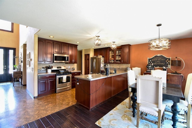 3001 Revere Rd, Plover, WI 54406 - kitchen with appliances with stainless steel finishes, a chandelier, light countertops, tasteful backsplash, and glass insert cabinets