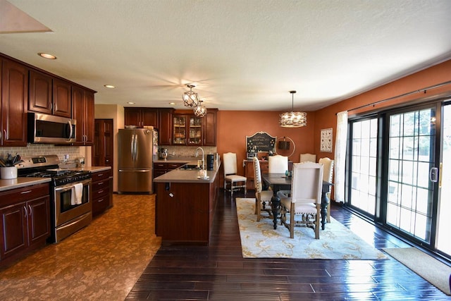 3001 Revere Rd, Plover, WI 54406 - kitchen with stainless steel appliances, a sink, a chandelier, tasteful backsplash, and dark wood-style flooring
