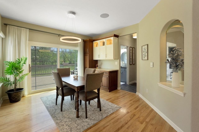 N53W16789 Prairie Dawn, Menomonee Falls, WI 53051 - dining space featuring light wood-type flooring, arched walkways, and baseboards