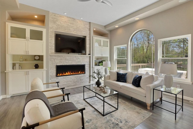 N53W16789 Prairie Dawn, Menomonee Falls, WI 53051 - living room featuring a stone fireplace, wood finished floors, recessed lighting, baseboards, and a ceiling fan