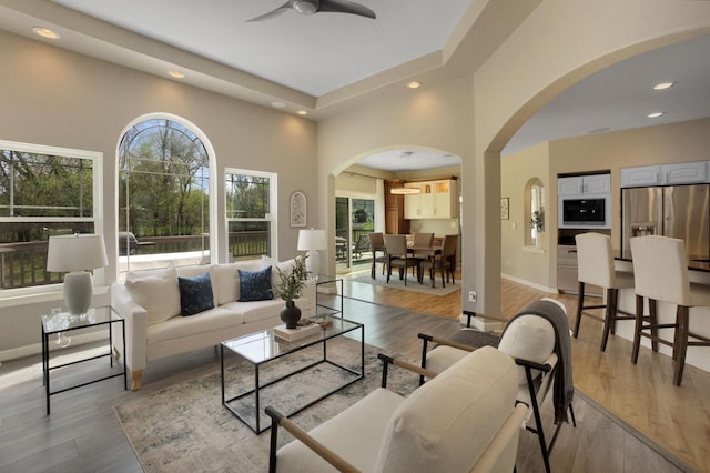 N53W16789 Prairie Dawn, Menomonee Falls, WI 53051 - living area with arched walkways, ceiling fan, light wood-style floors, recessed lighting, and baseboards