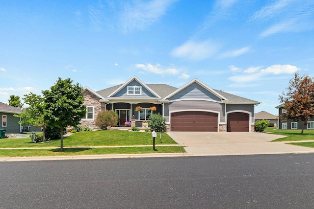 805 Mourning Dove Dr, Cottage Grove, WI 53527 - craftsman inspired home with stone siding, a garage, a front lawn, driveway, and a porch