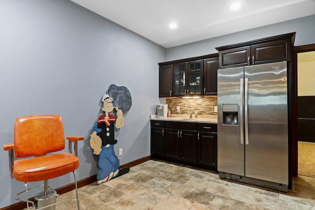 805 Mourning Dove Dr, Cottage Grove, WI 53527 - kitchen with stainless steel fridge with ice dispenser, backsplash, light stone finish floors, light countertops, and glass insert cabinets