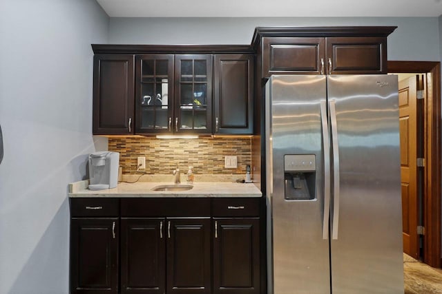 805 Mourning Dove Dr, Cottage Grove, WI 53527 - kitchen featuring stainless steel refrigerator with ice dispenser, tasteful backsplash, light stone countertops, glass insert cabinets, and dark brown cabinets